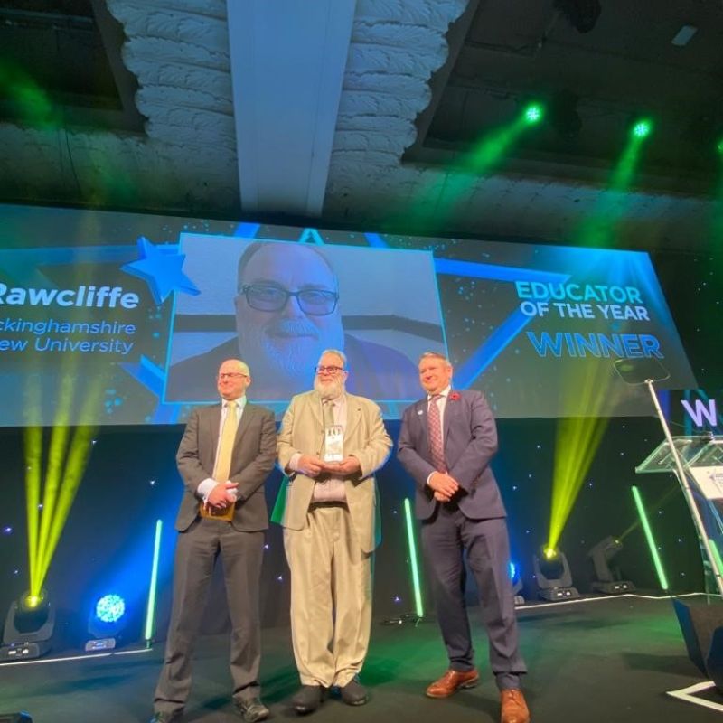 David Rawcliffe accepts Educator of the Year award on stage