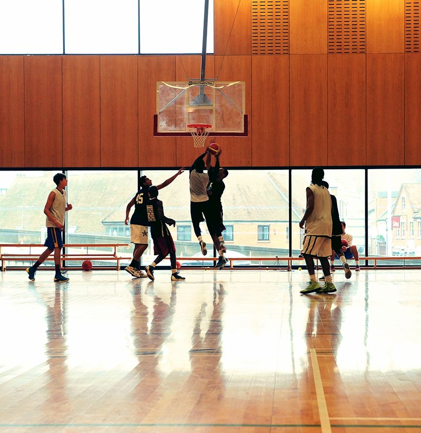 Men playing basketball in the sports hall