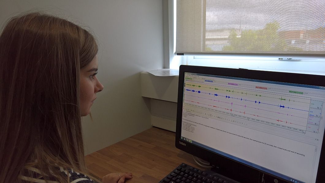 A student looking at a computer screen which has various graphs on