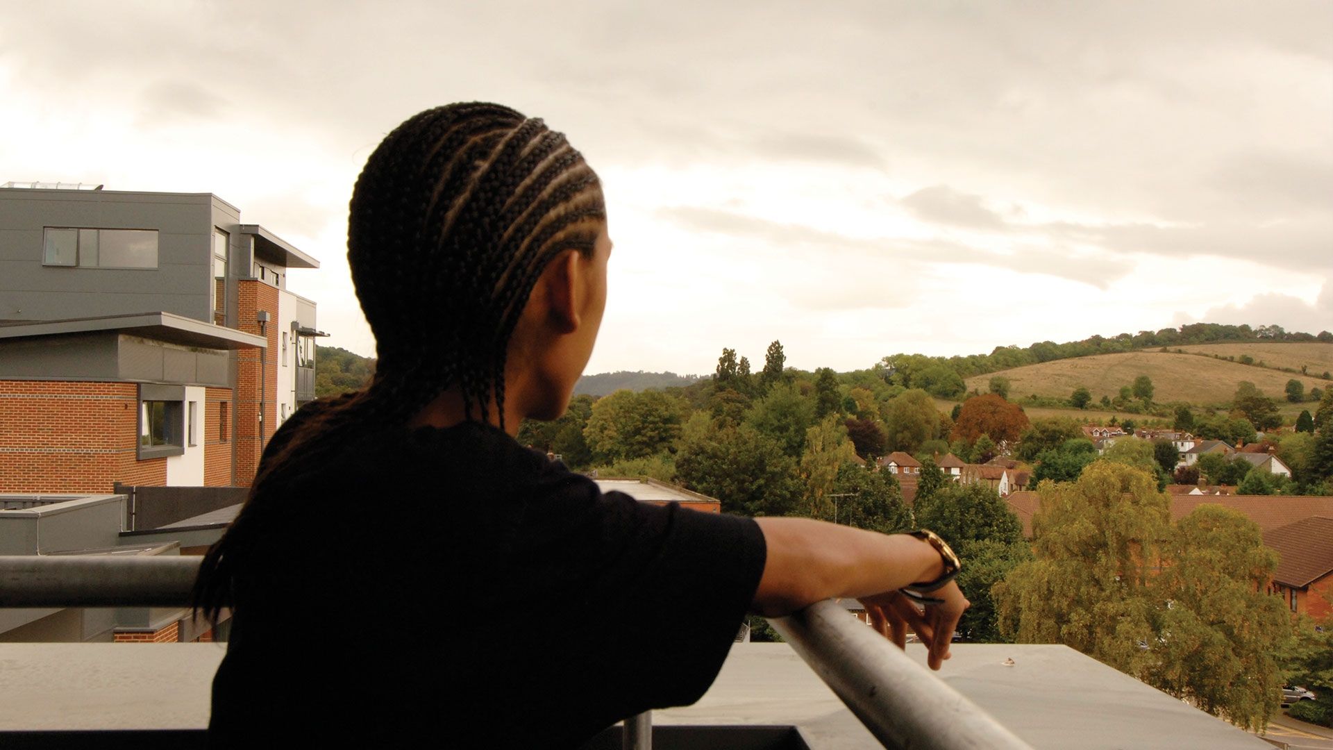 Bucks student standing on balcony of student halls looking over fields