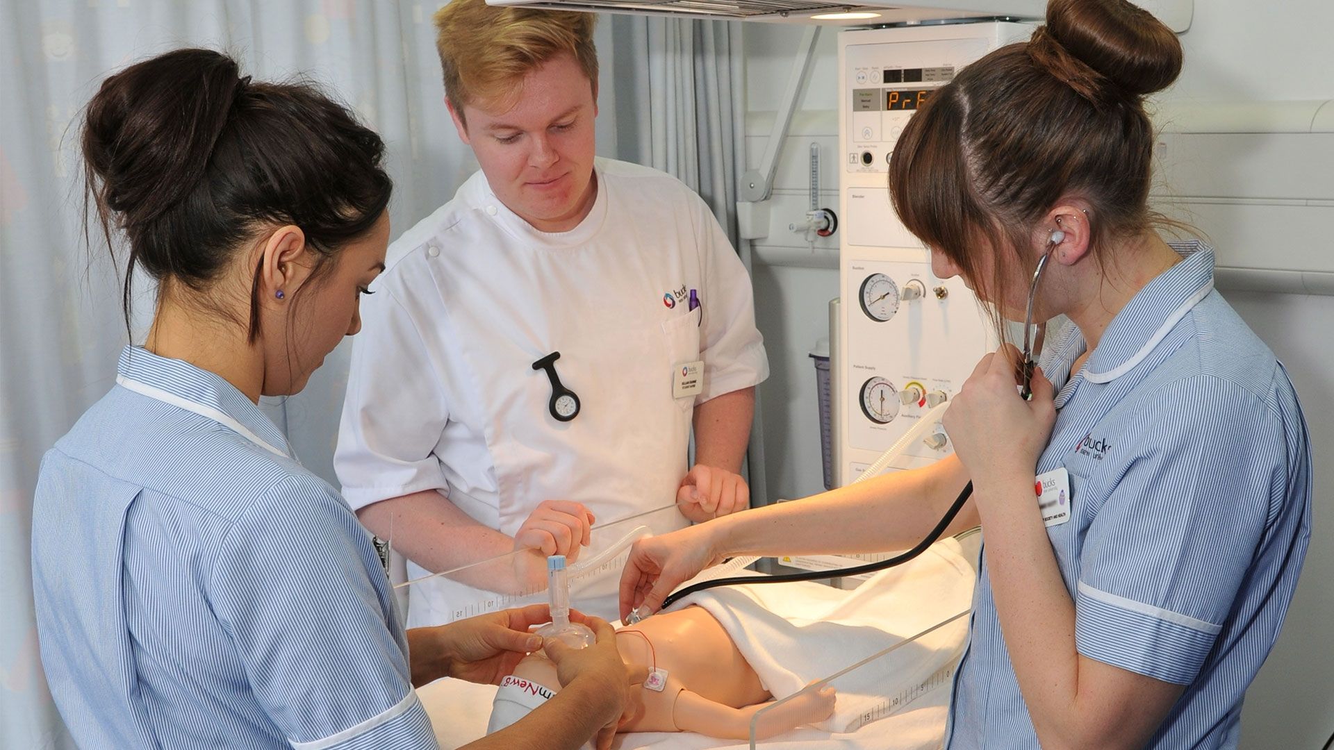Three Bucks student nurses using a stethoscope on a child mannequin