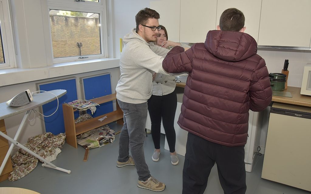 Students discussing their work in a practice kitchen scene