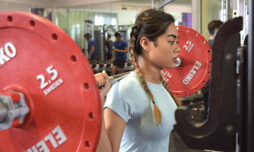A female student lifting weights in the gateway gym