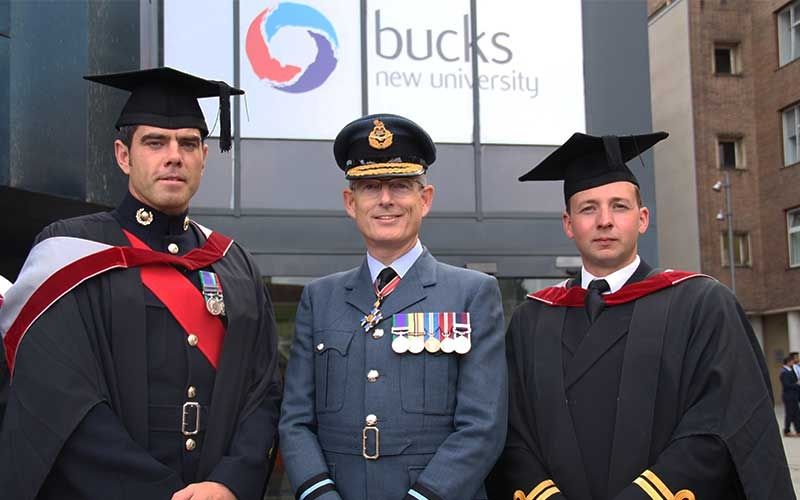 Air Commodore Richard Hill stood in the middle of two male graduates