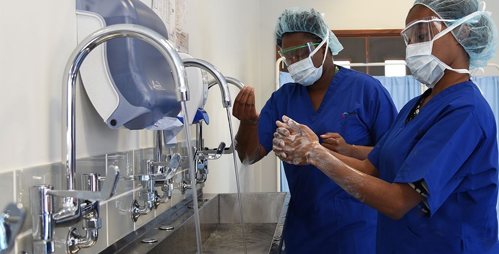Two Bucks ODP students in scrubs and masks washing their hands