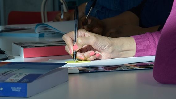 A student holding a pen in their right hand