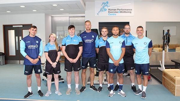 A group of Wycombe FC players stood with BNU student Heather