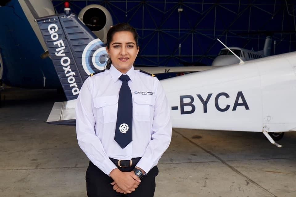 Female Aviation student standing in front of a plane