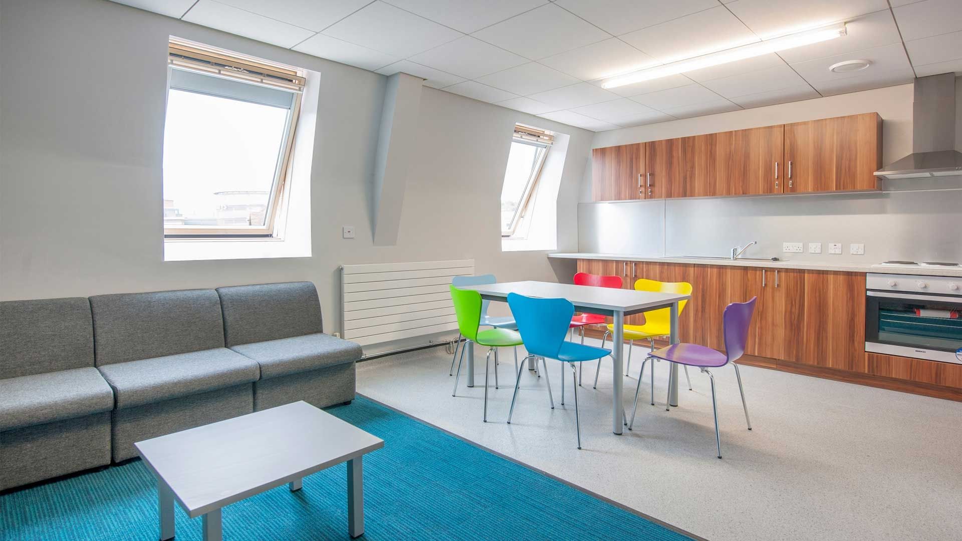 a sofa, table and chairs and kitchen fittings and equipment inside Windsor House accommodation