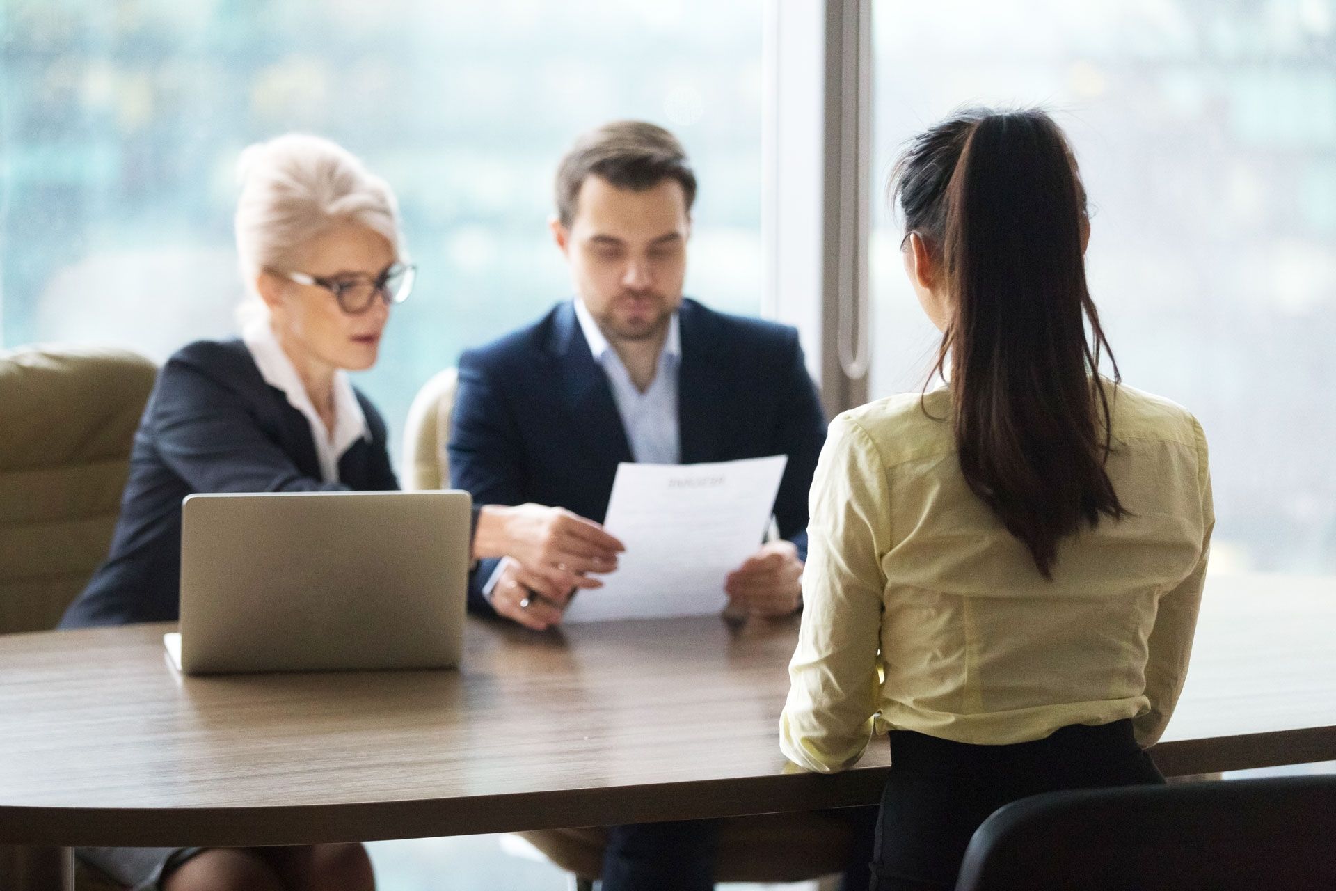 Young adult being interviewed by two people in a private office