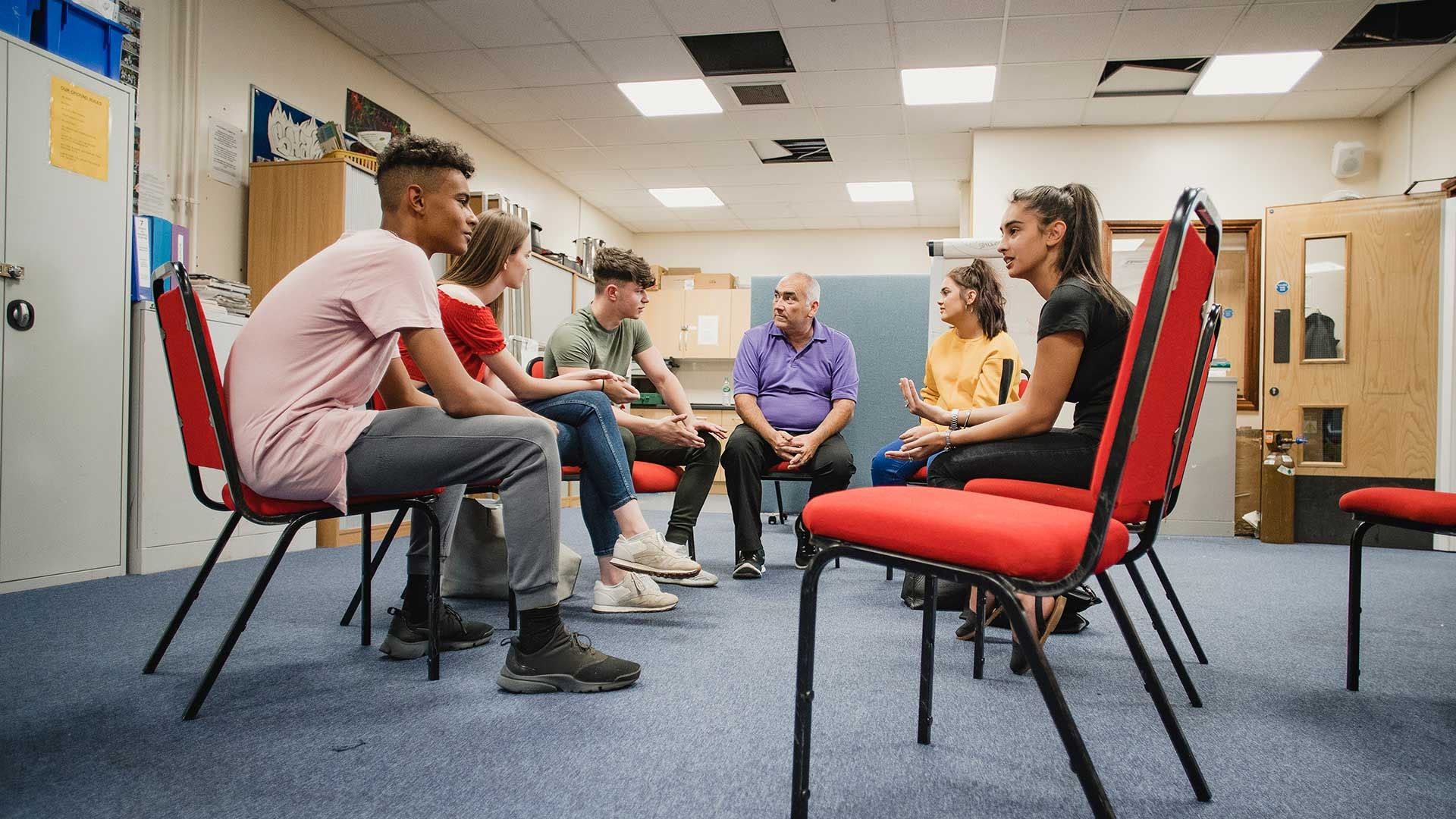 young adults sitting together in circle talking 