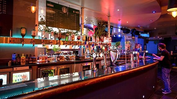 Students' Union bar with a student talking to the bar staff