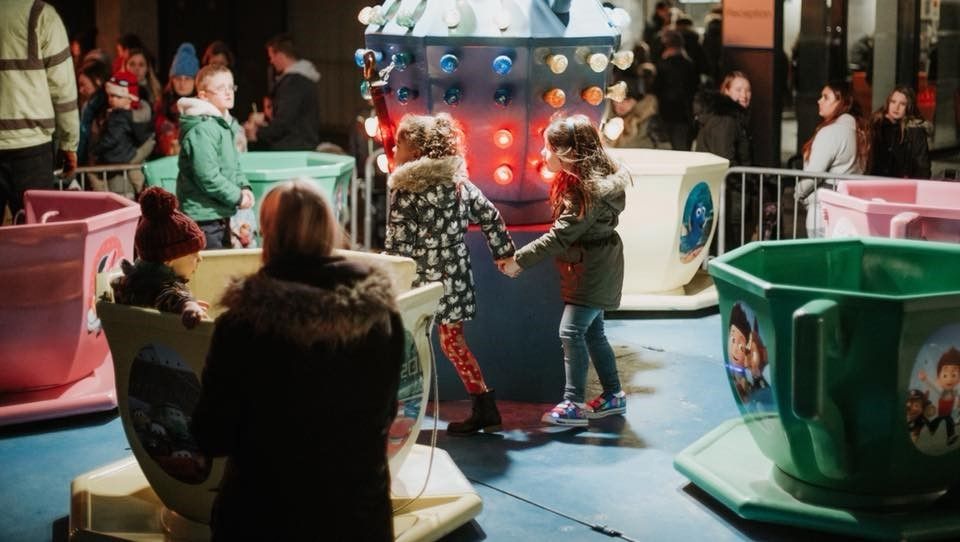 children on teacup rides at event near gateway building