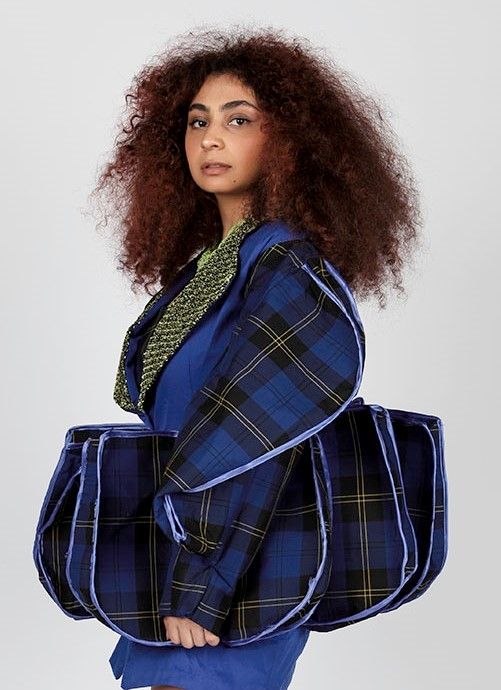 Fashion Design Student work stood in blue outfit