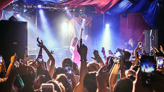 A Bucks Students' Union event held in a music concert with students waving their arms in the air whilst looking towards the stage
