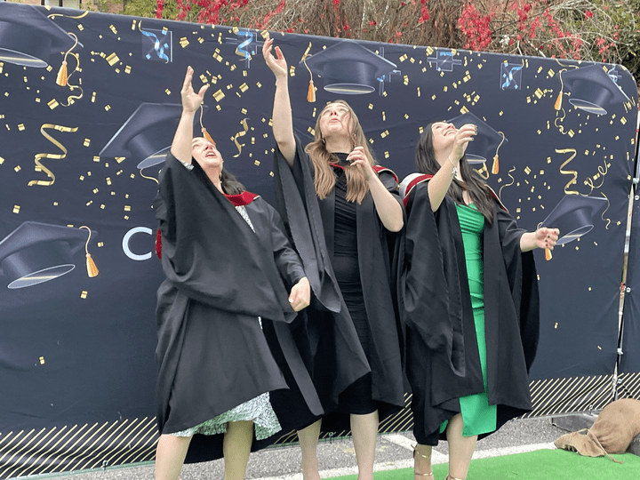 Graduation Class of 2021 students throwing mortar board hats