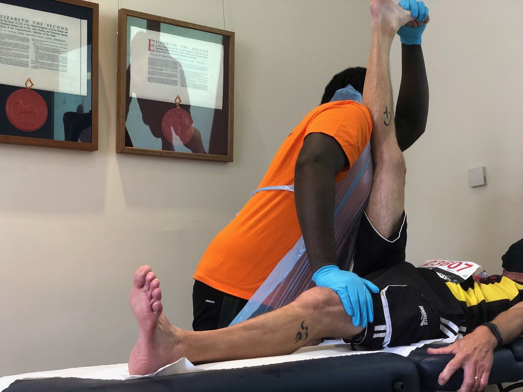 Students in MNDA uniform and PPE carrying out sports therapies on athletes