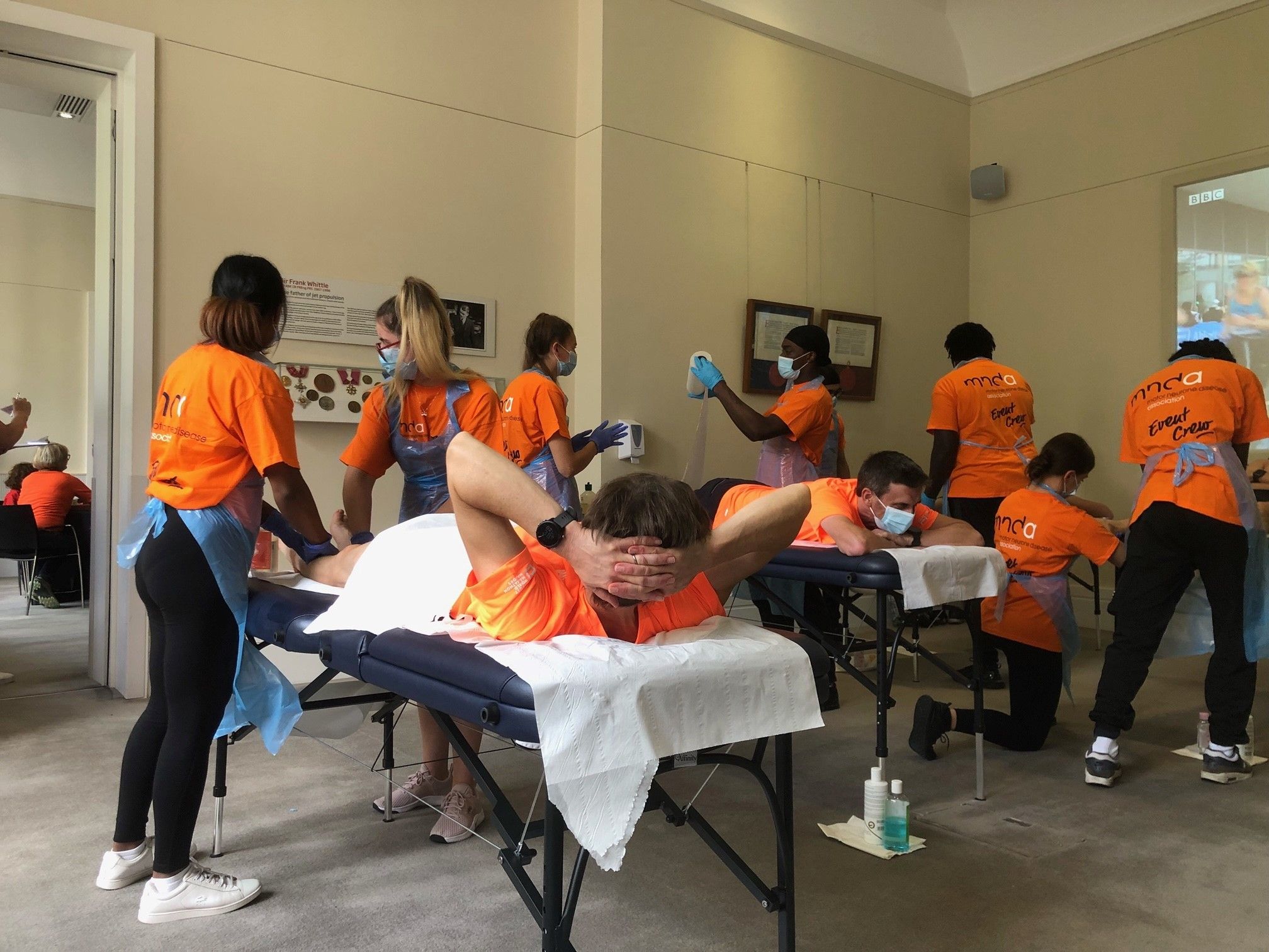 Students in MNDA uniform and PPE carrying out sports therapies on athletes