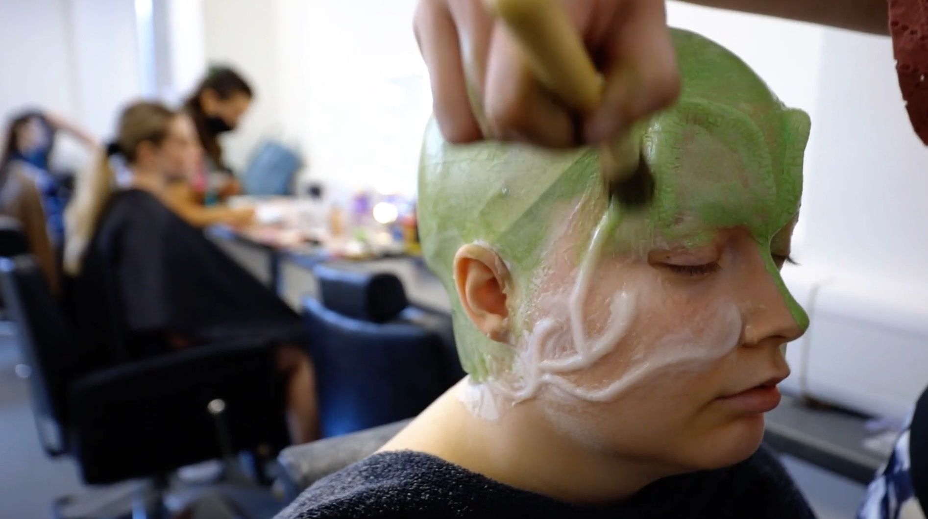 Student wearing green prosthetics on face