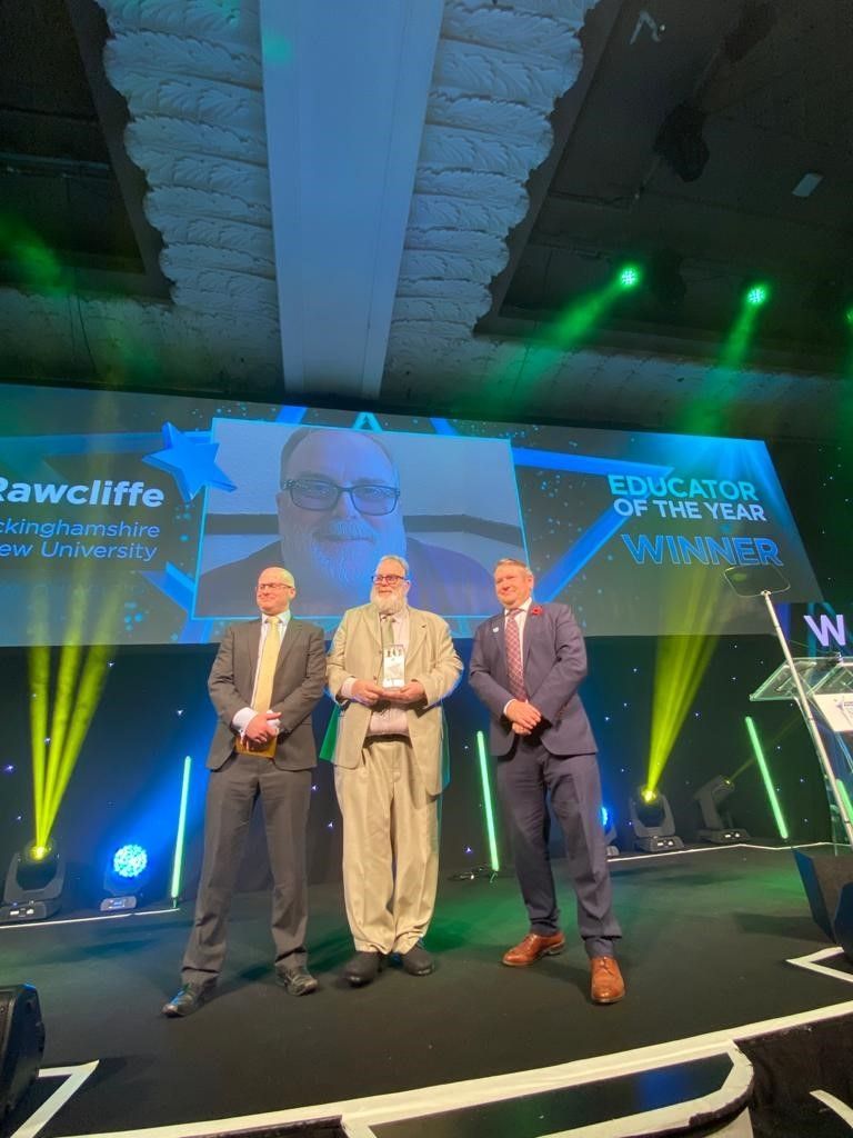 David Rawcliffe accepts Educator of the Year award on stage