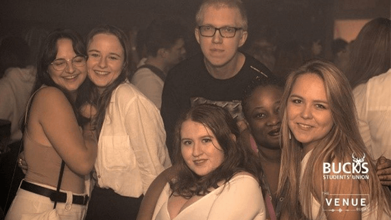 6 BNU students stood next to one another posing for a photo in a nightclub 