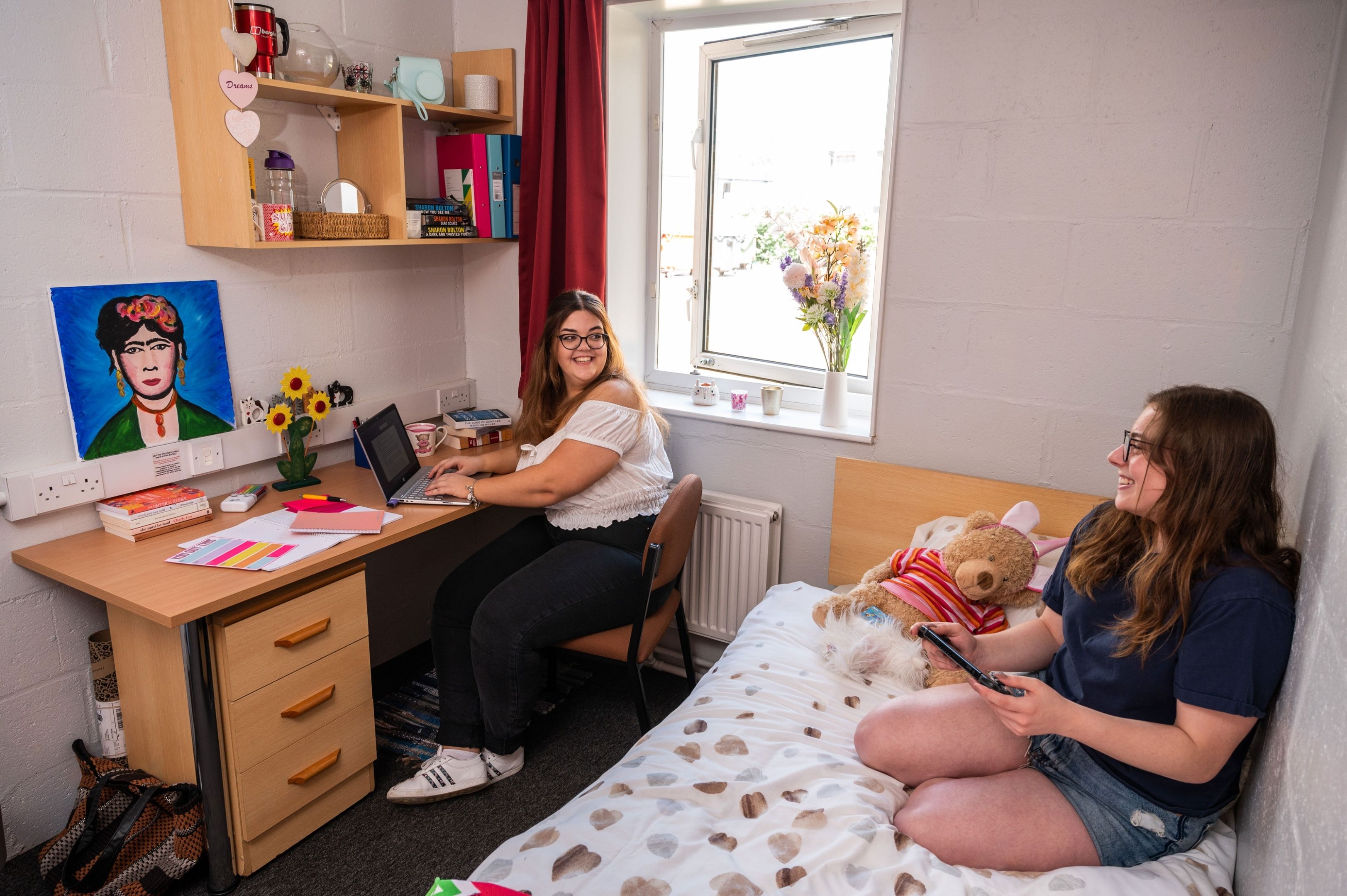 Two female students chatting in bedroom at Brook Street accommodation