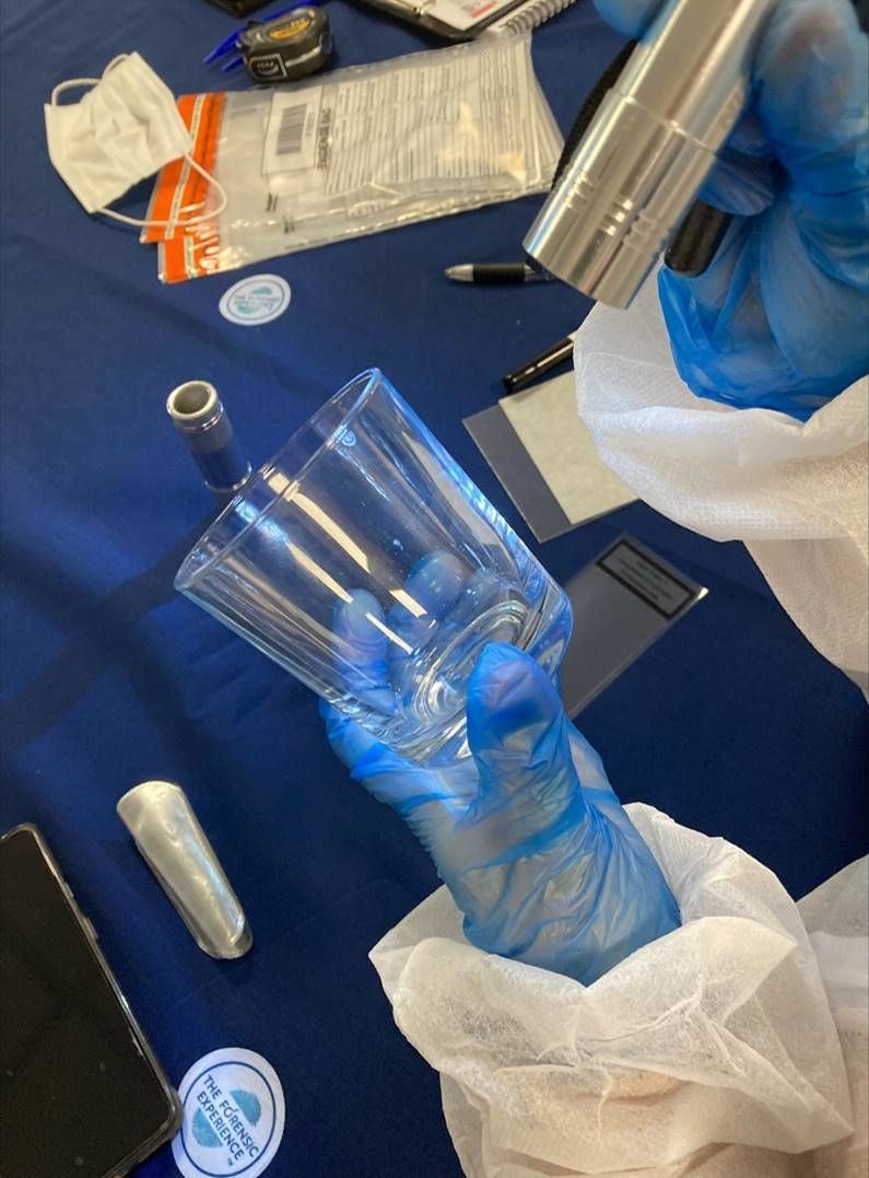 student holding criminology items during forensic studies