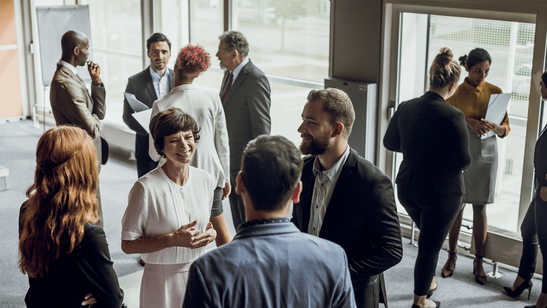 A small group of people stood in a waiting area having a meeting