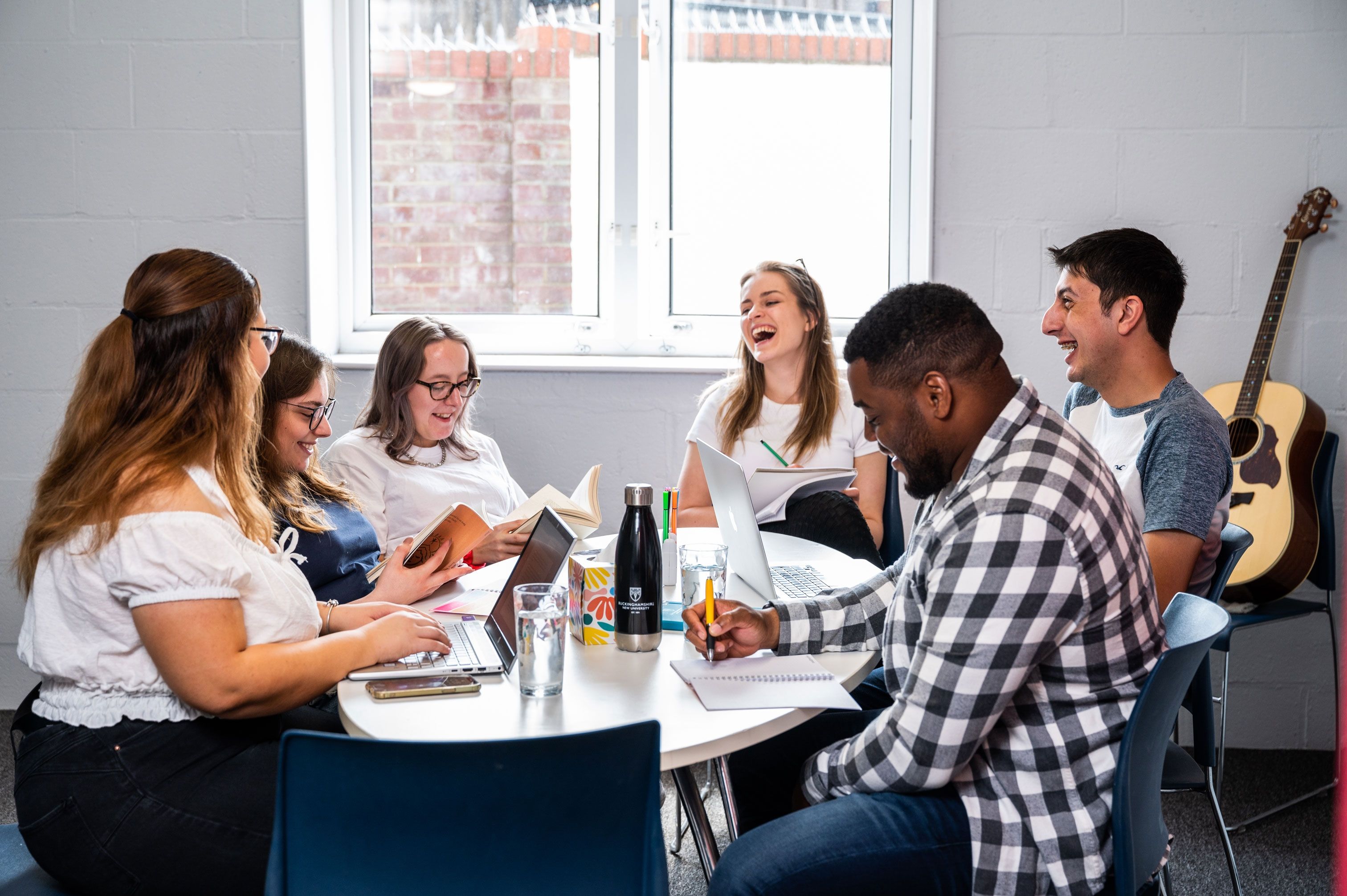 Group of students sitting at the table at Brook Street accommodation in High Wycombe campus