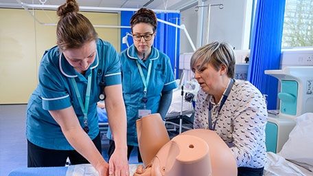 Midwifery students with dummy