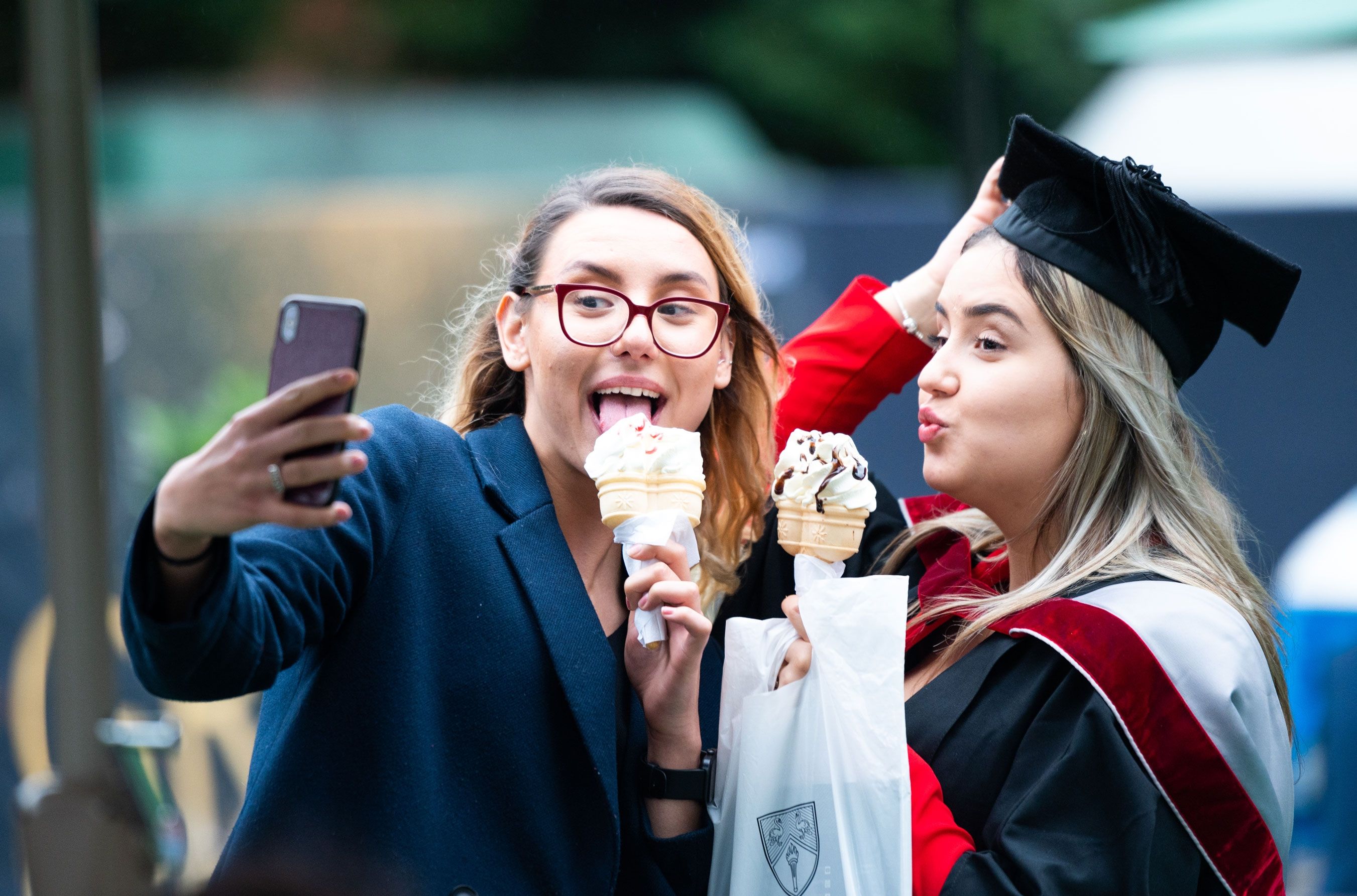 Female graduand taking a selfie with friend
