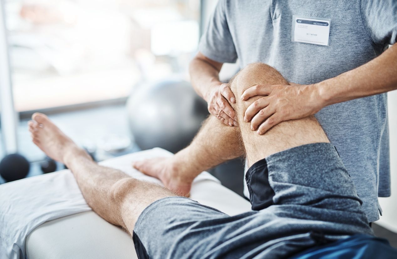 patient having knee massaged by physiotherapist