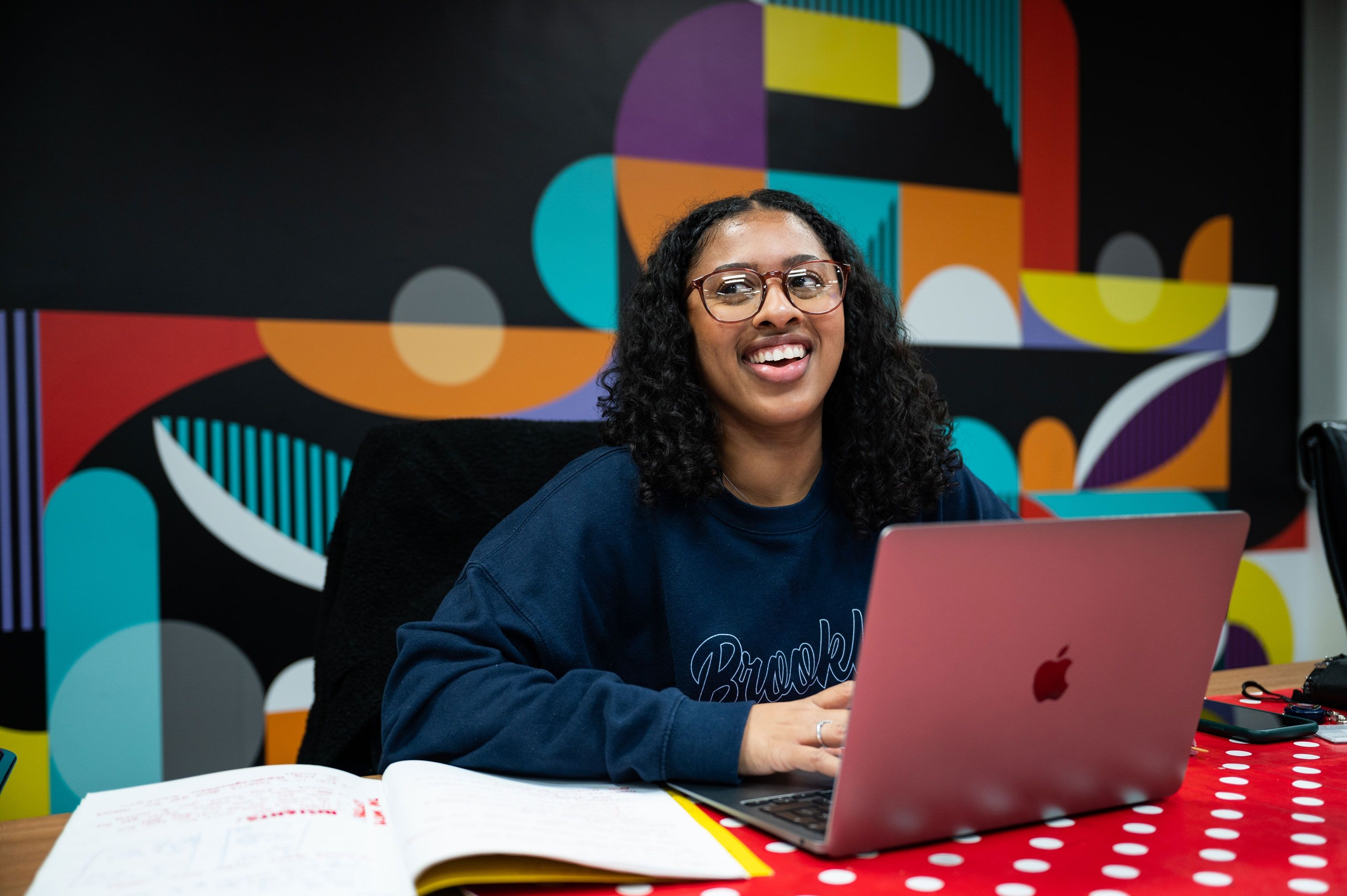 Creative Advertising student at laptop smiling