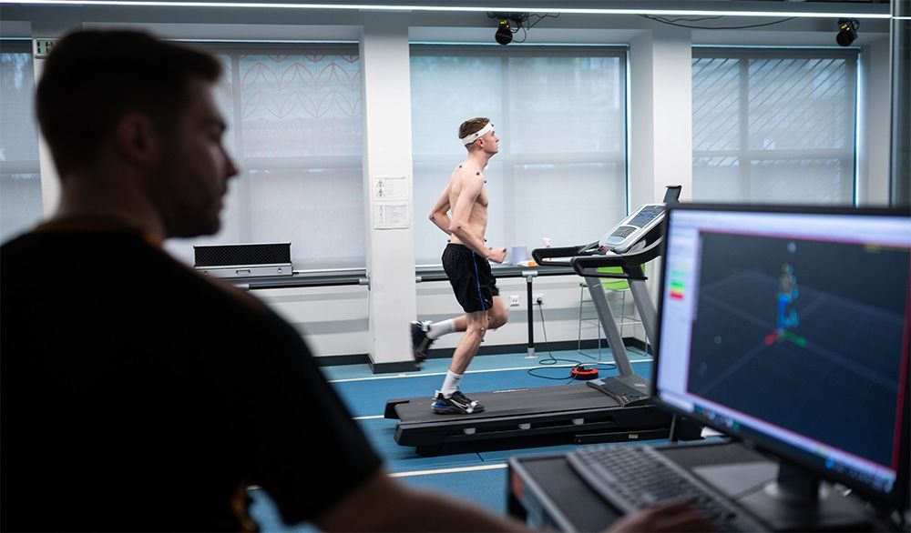 A Sports Therapy student on a treadmill as another student monitors performance on a computer.