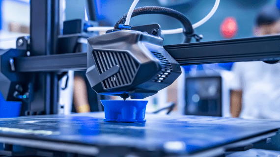 A 3D printing machine printing a blue object.