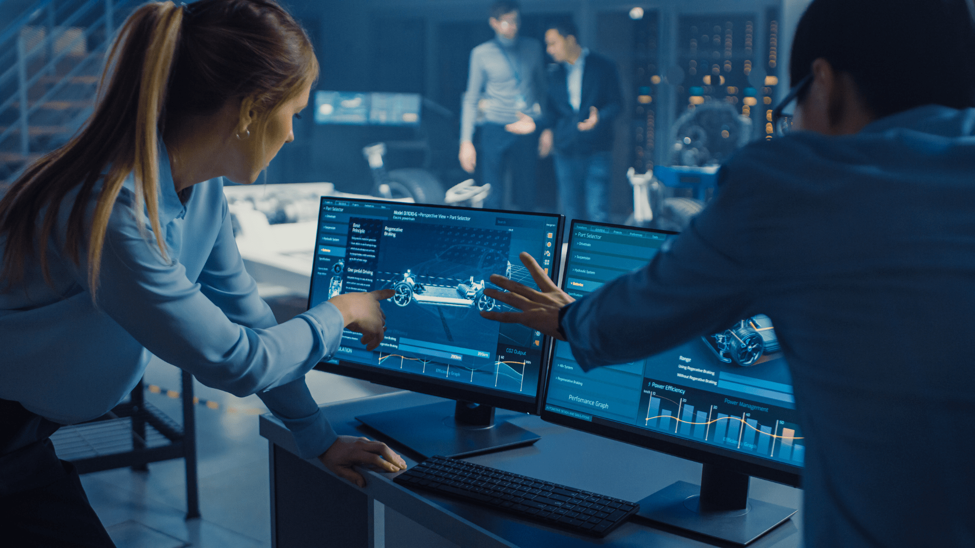 Two students pointing and looking at a computer screen which has digital drawings on.
