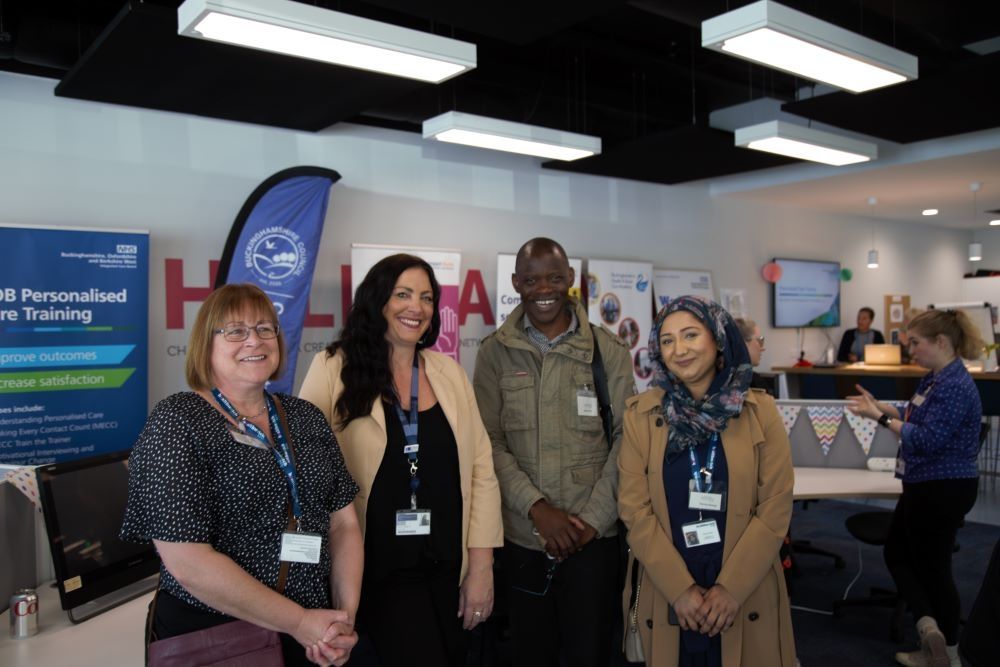 Staff standing together and smiling in the wellbeing hub
