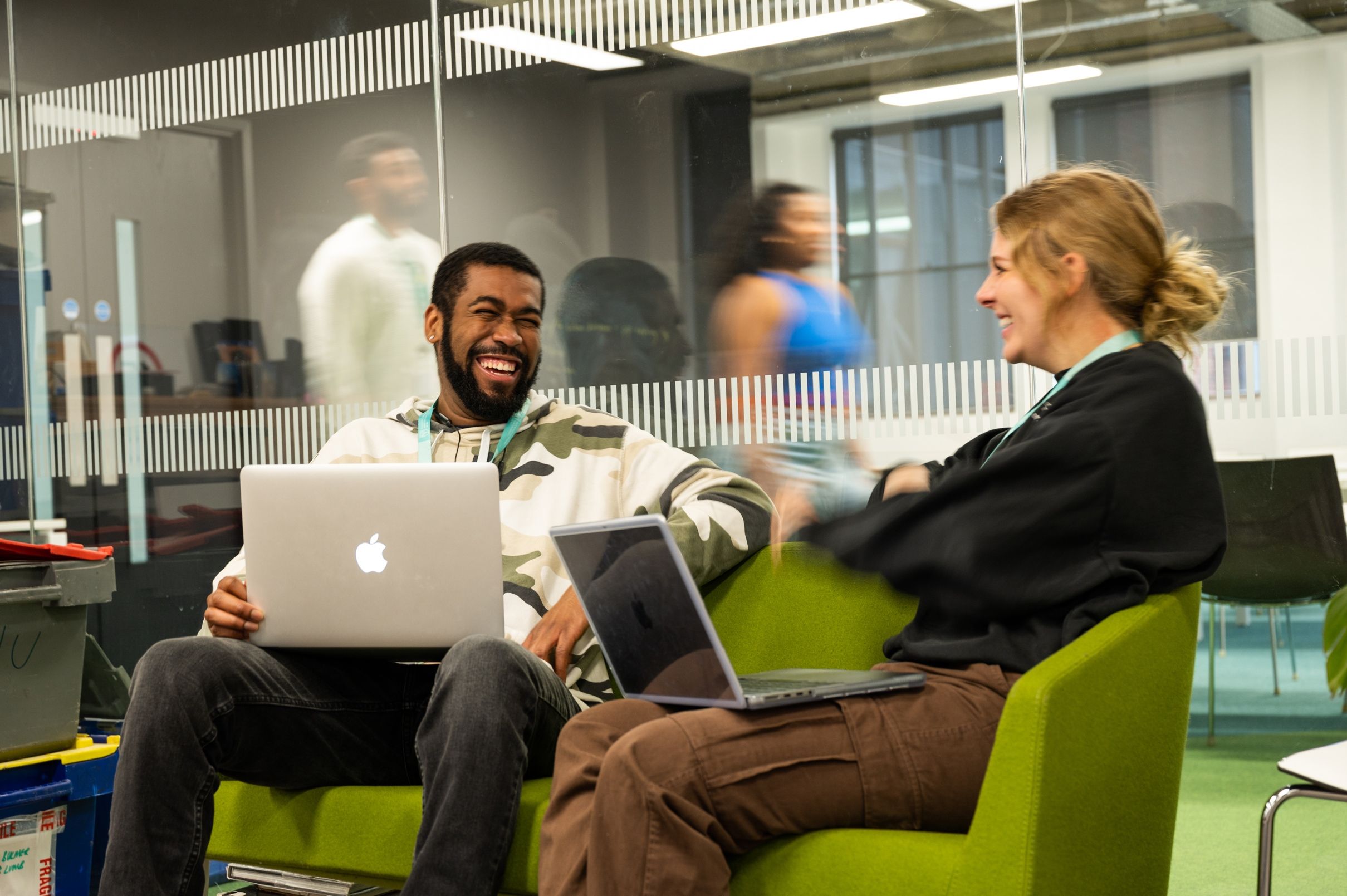Two students with laptops in a classroom