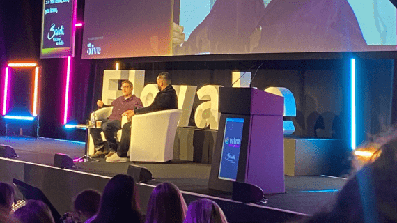 Louis Theroux sat down alongside a presenter giving a talk to people attending the World Tourism Market event 2023.