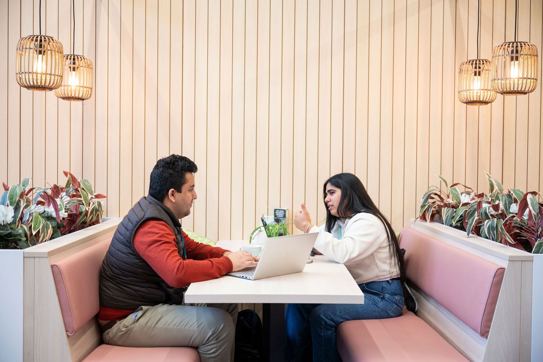 Two students in a booth at the Garden Cafe