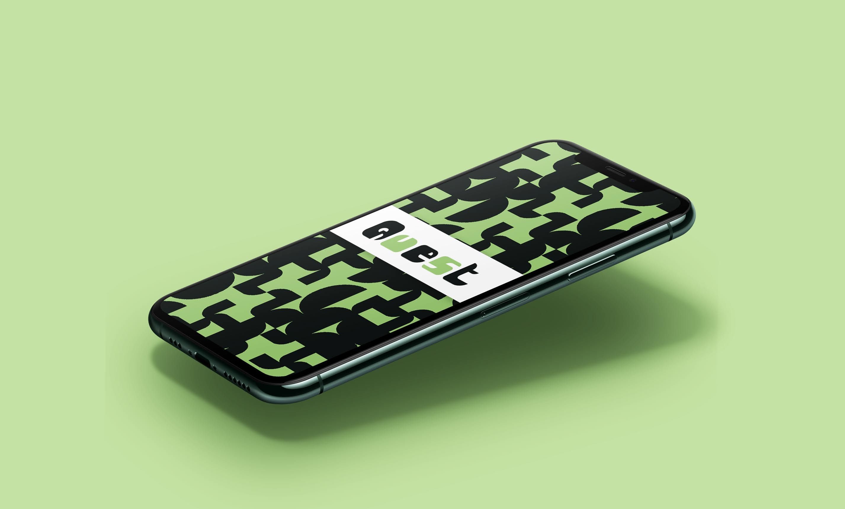 A phone screen slightly elevated which has the word "Quest" written with green and black shapes around it.