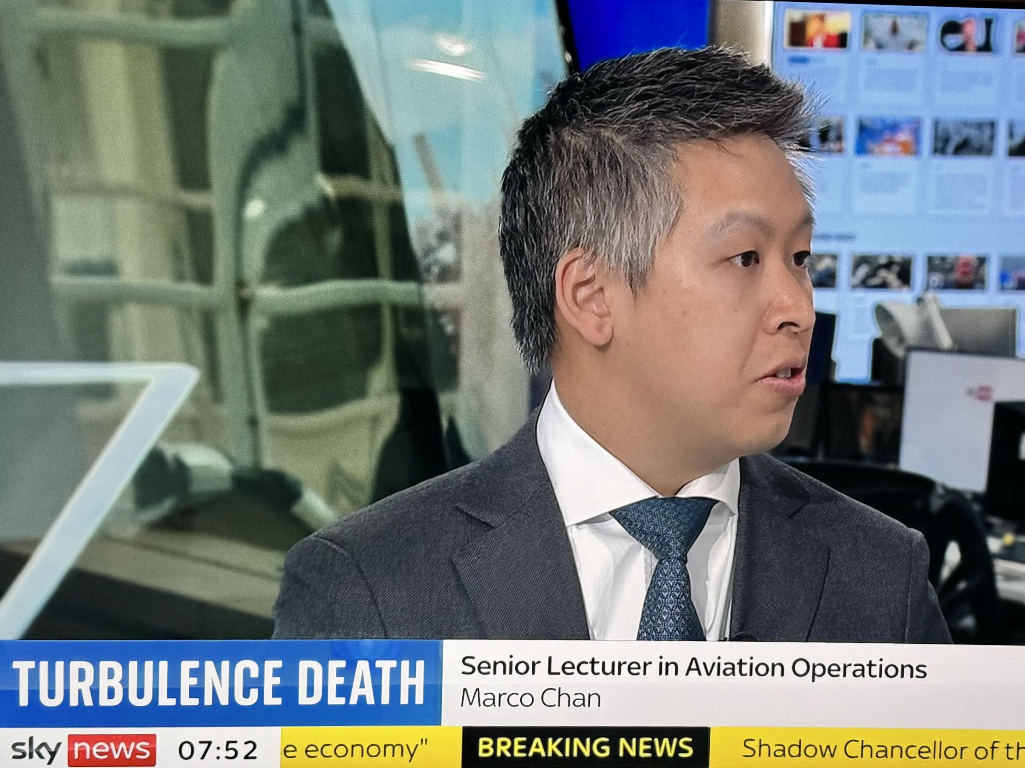 Man in a suit appearing on Sky News with his head turned as if talking to someone.