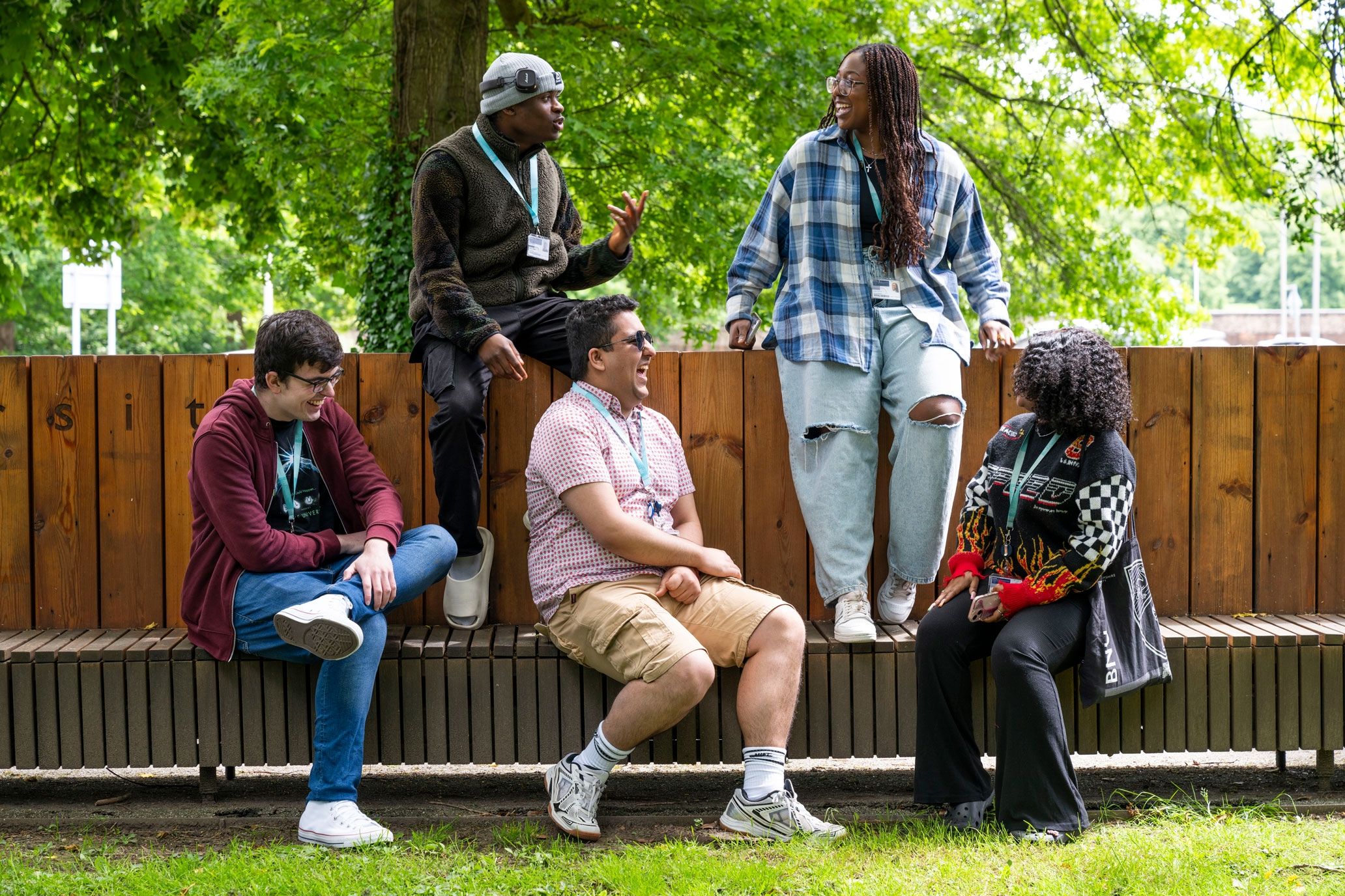 Five students sitting on a bench at High Wycombe campus