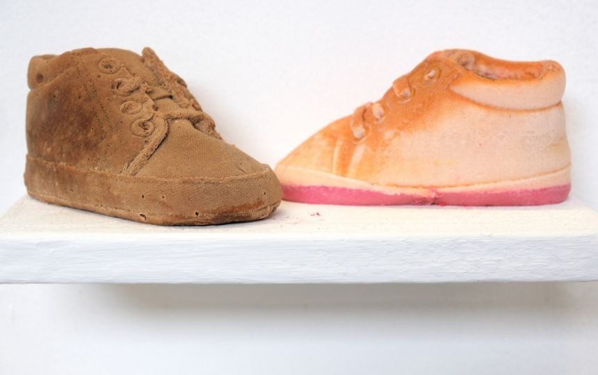 A brown shoe next to a orange shoe.
