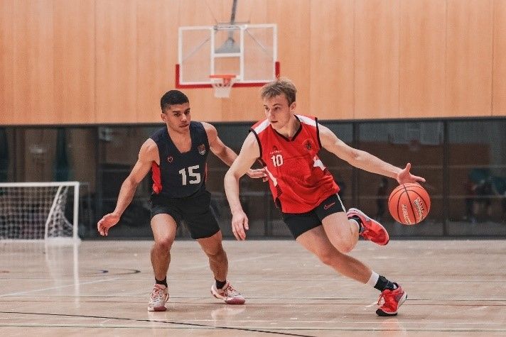 Two students playing basketball
