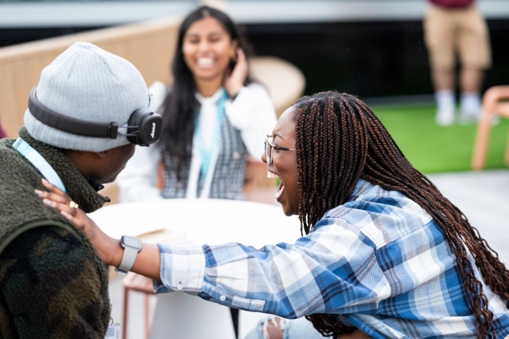 Students laughing while sitting at a table