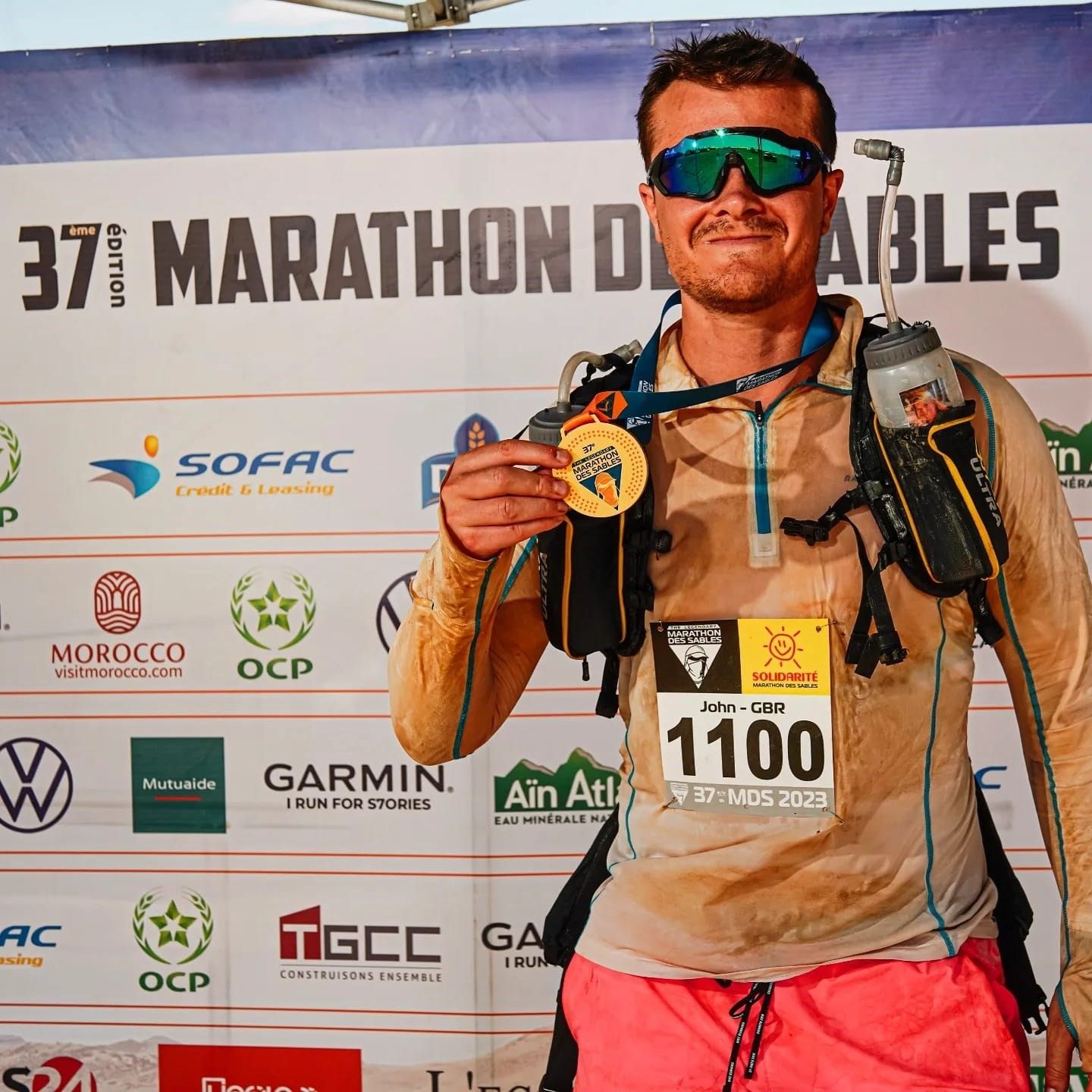 man standing with a medal after a race.