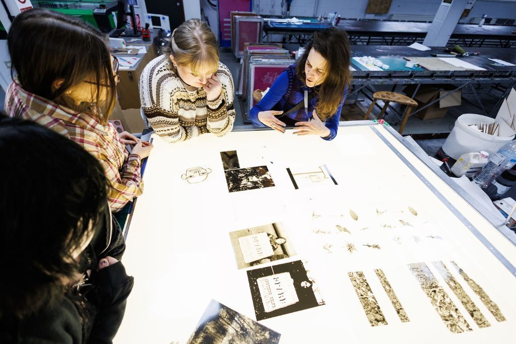 Fine art lecturer discussing with students