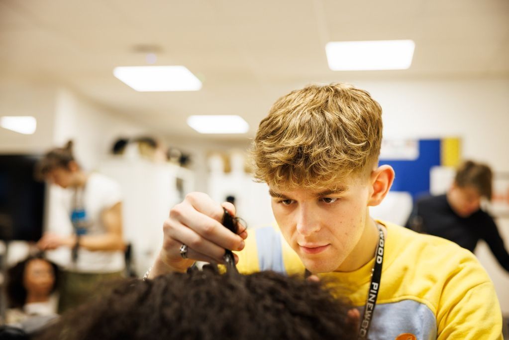 A Hair and Make-up student practicing techniques on a models hair.