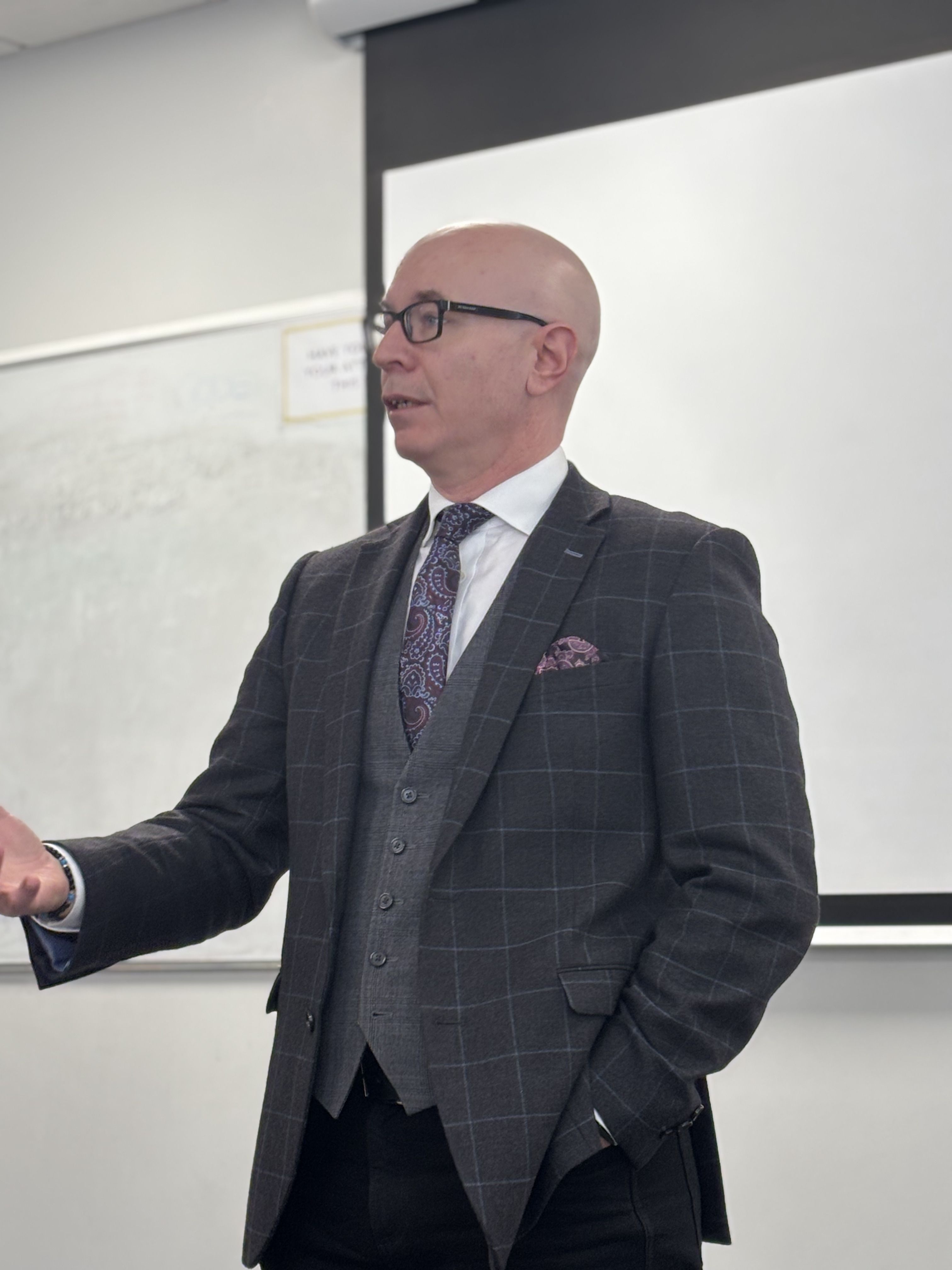 A man in a suit giving a lecture